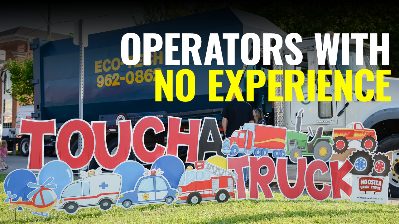 Photo of young boy standing by Touch A Truck sign