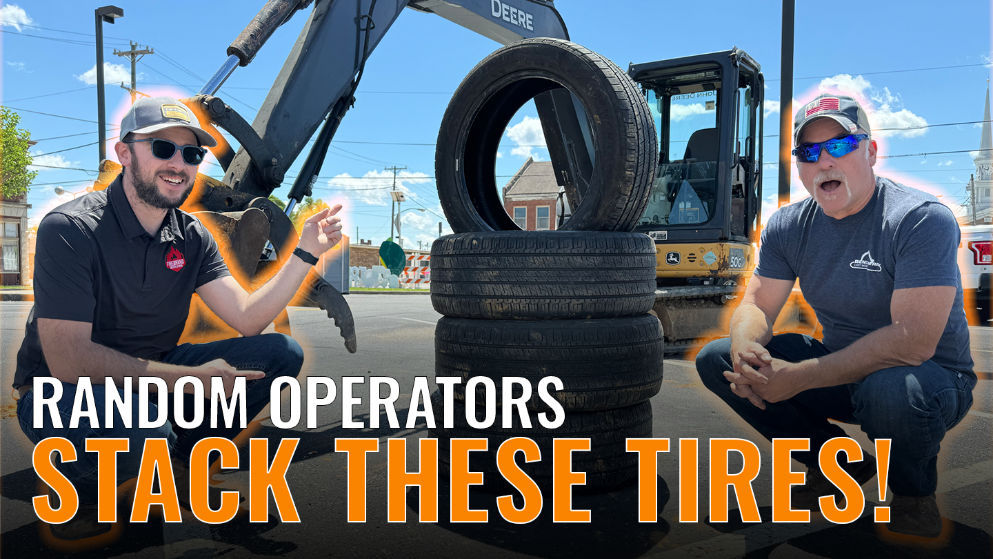 Two men sitting by a stack of tires in front of an excavator